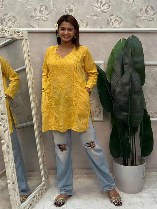 Yellow cotton short chikankari kurta with hand embroidery and side pockets.