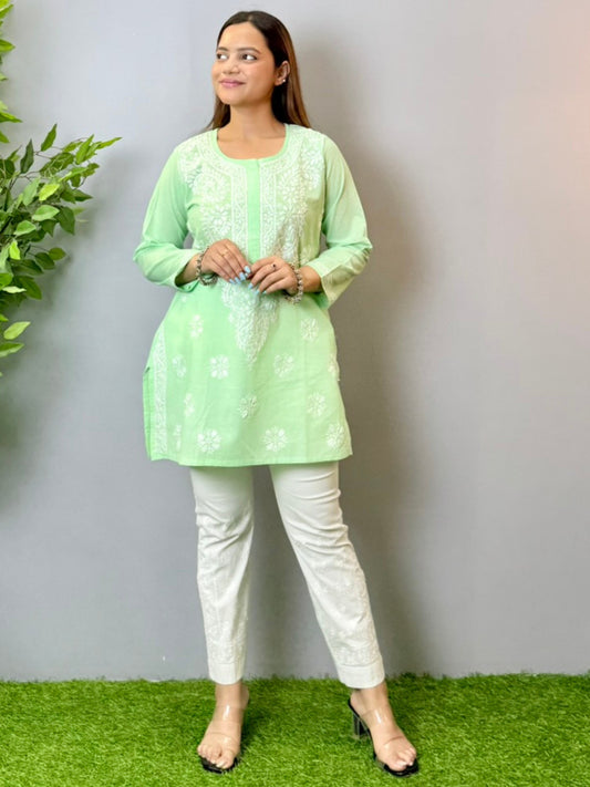 Model wearing a mint green cotton short Lucknowi chikankari kurta with white embroidery, paired with white straight pants.