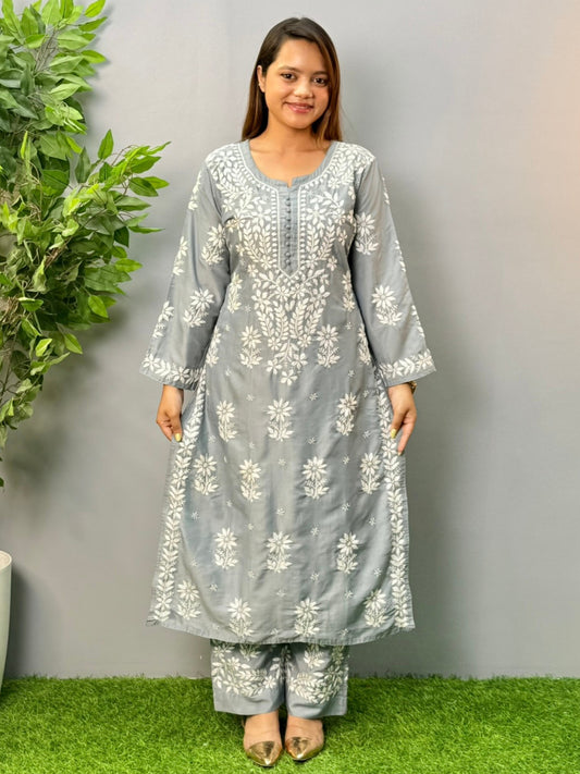 Model wearing a steel grey muslin chikankari kurta and pant set with intricate white embroidery