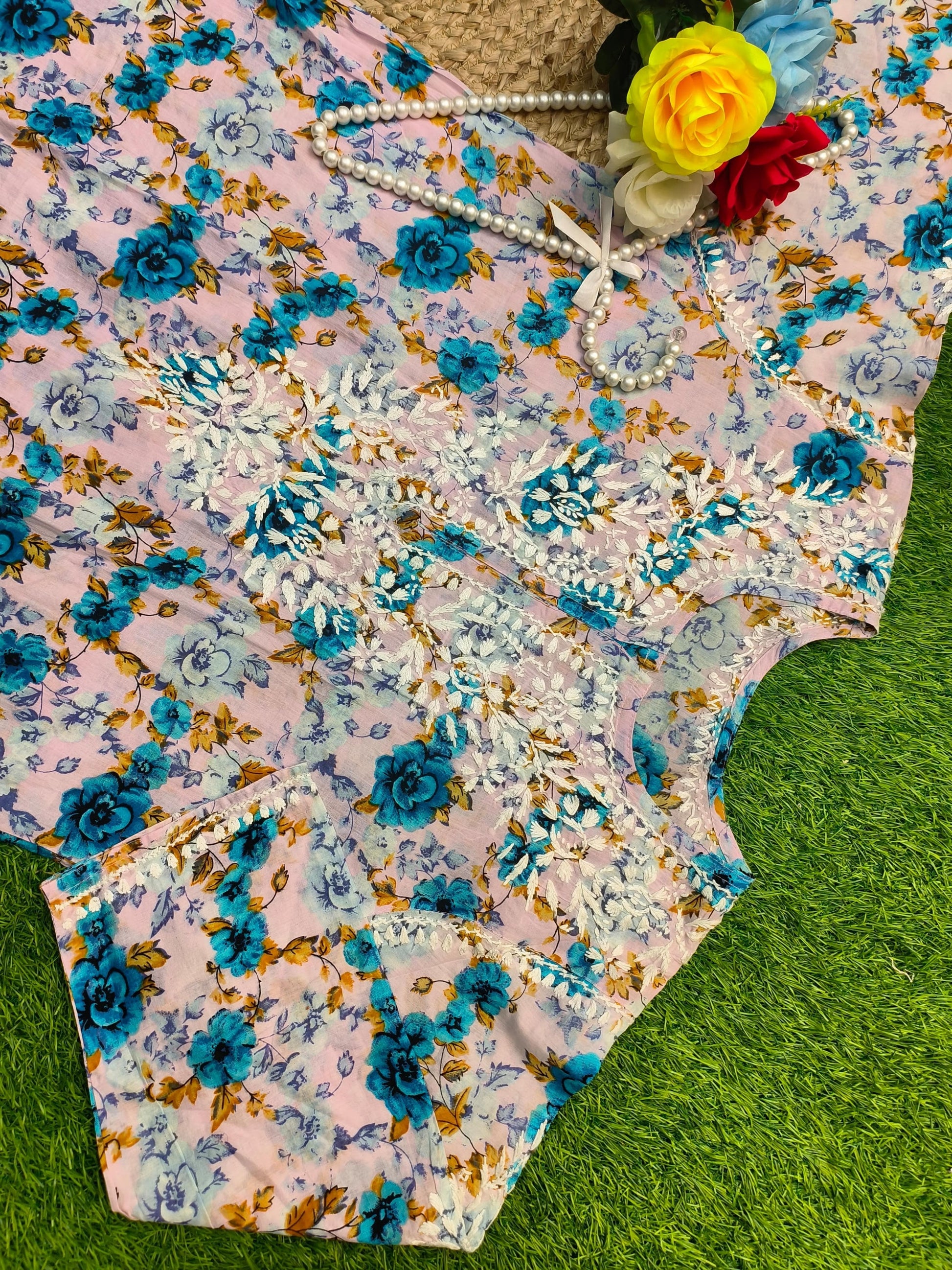 Flat lay of premium big size soft pink mulmul Lucknowi Chikankari kurta with vibrant blue floral print and white embroidery, by R S CHIKANKARI.