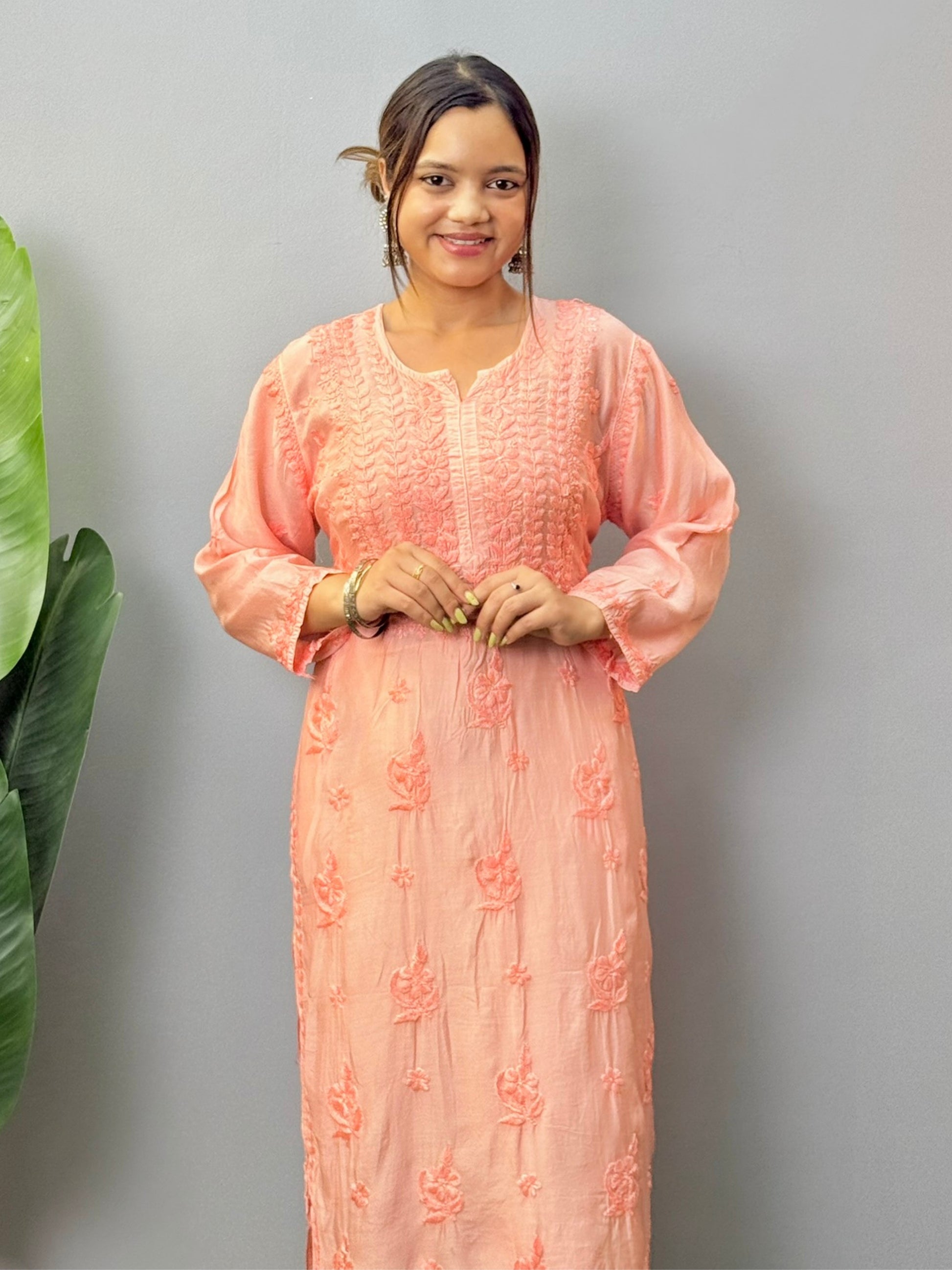 Model wearing peach muslin chikankari kurta with white bottom
