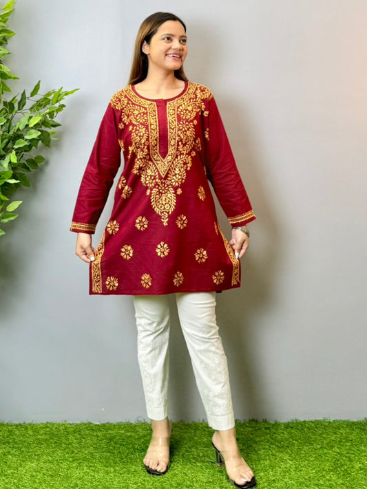 Model wearing a maroon short cotton Lucknowi chikankari kurta with mustard embroidery, styled with white pants.
