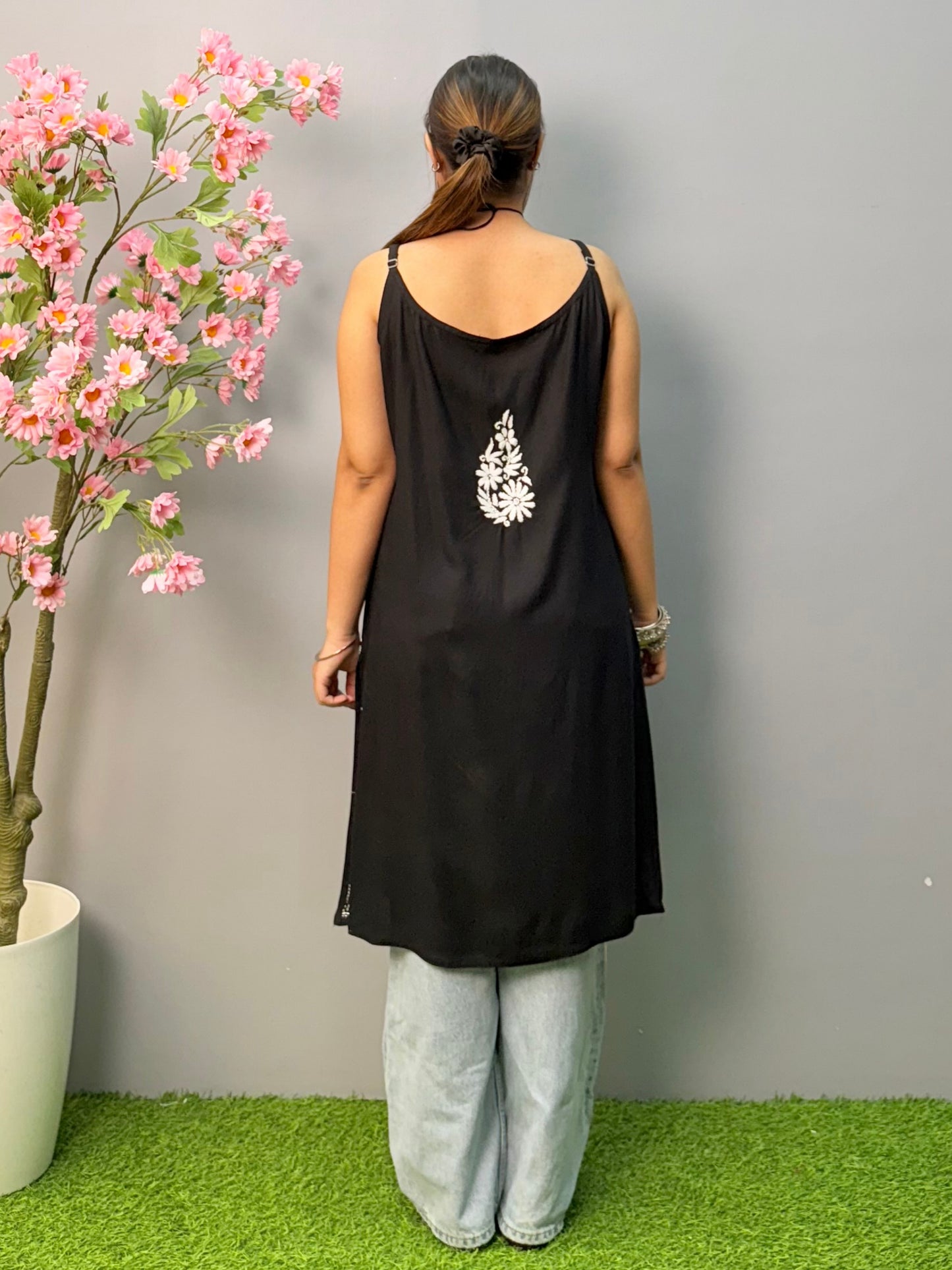 Black sleeveless rayon chikankari short kurta with white hand embroidery, soft and comfortable.