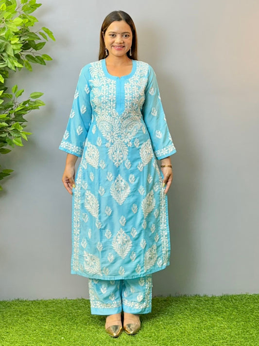 Woman wearing sky blue muslin Chikankari kurta and pant set with intricate white embroidery