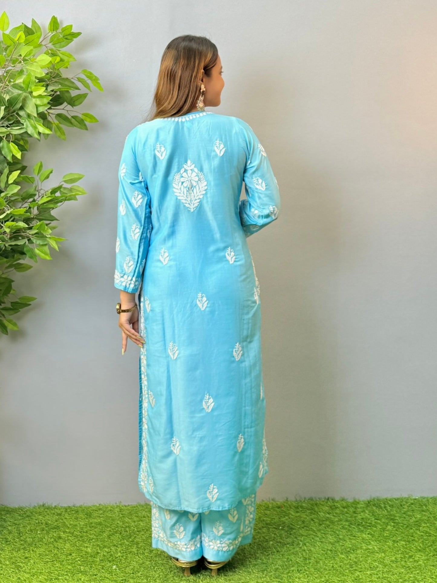 Woman wearing sky blue muslin Chikankari kurta and pant set with intricate white embroidery