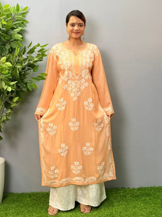 Model wearing a peach orange modal chikankari kurta with detailed white floral hand embroidery