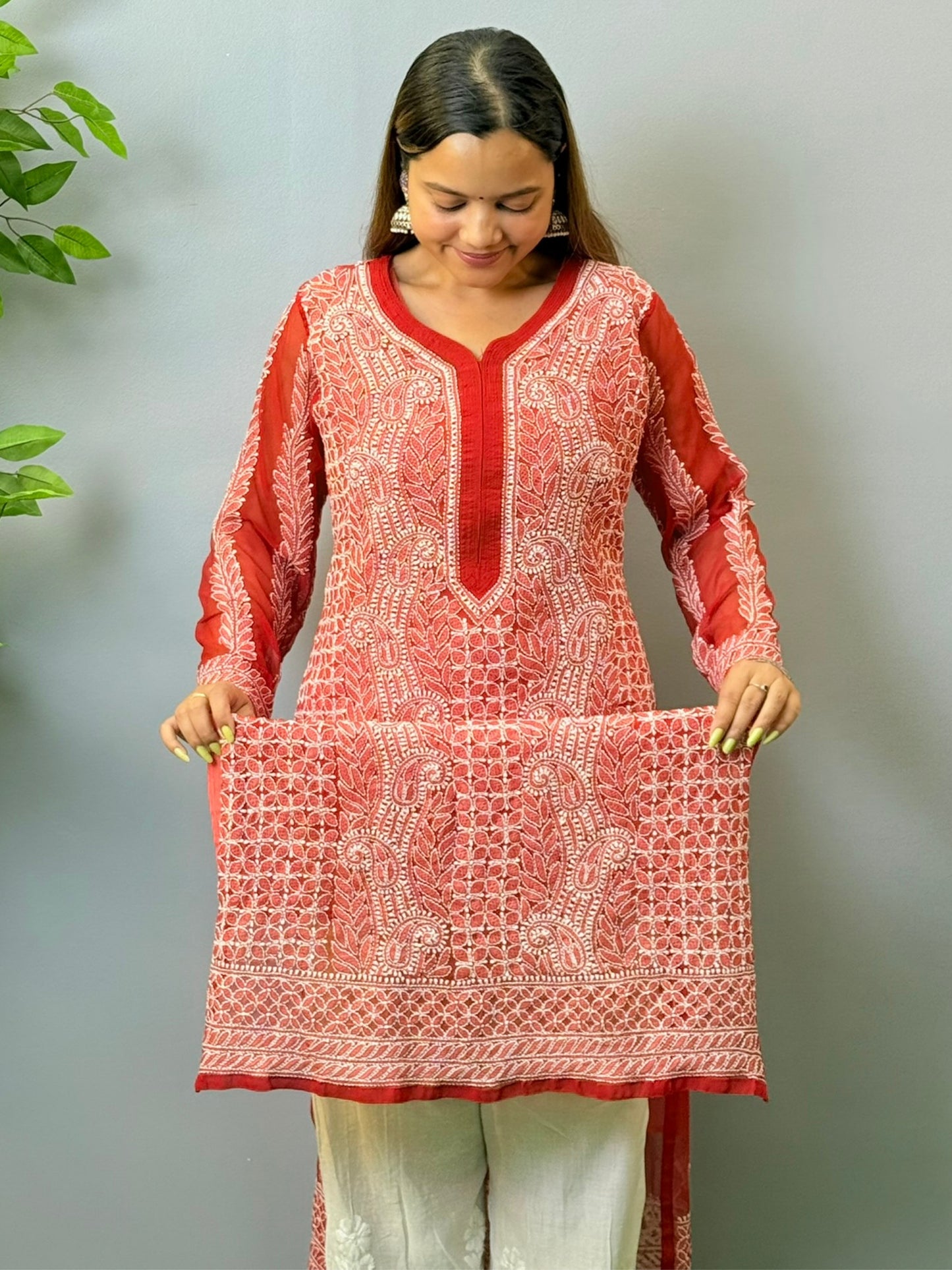 Woman wearing tomato red georgette chikankari kurta with heavy white embroidery