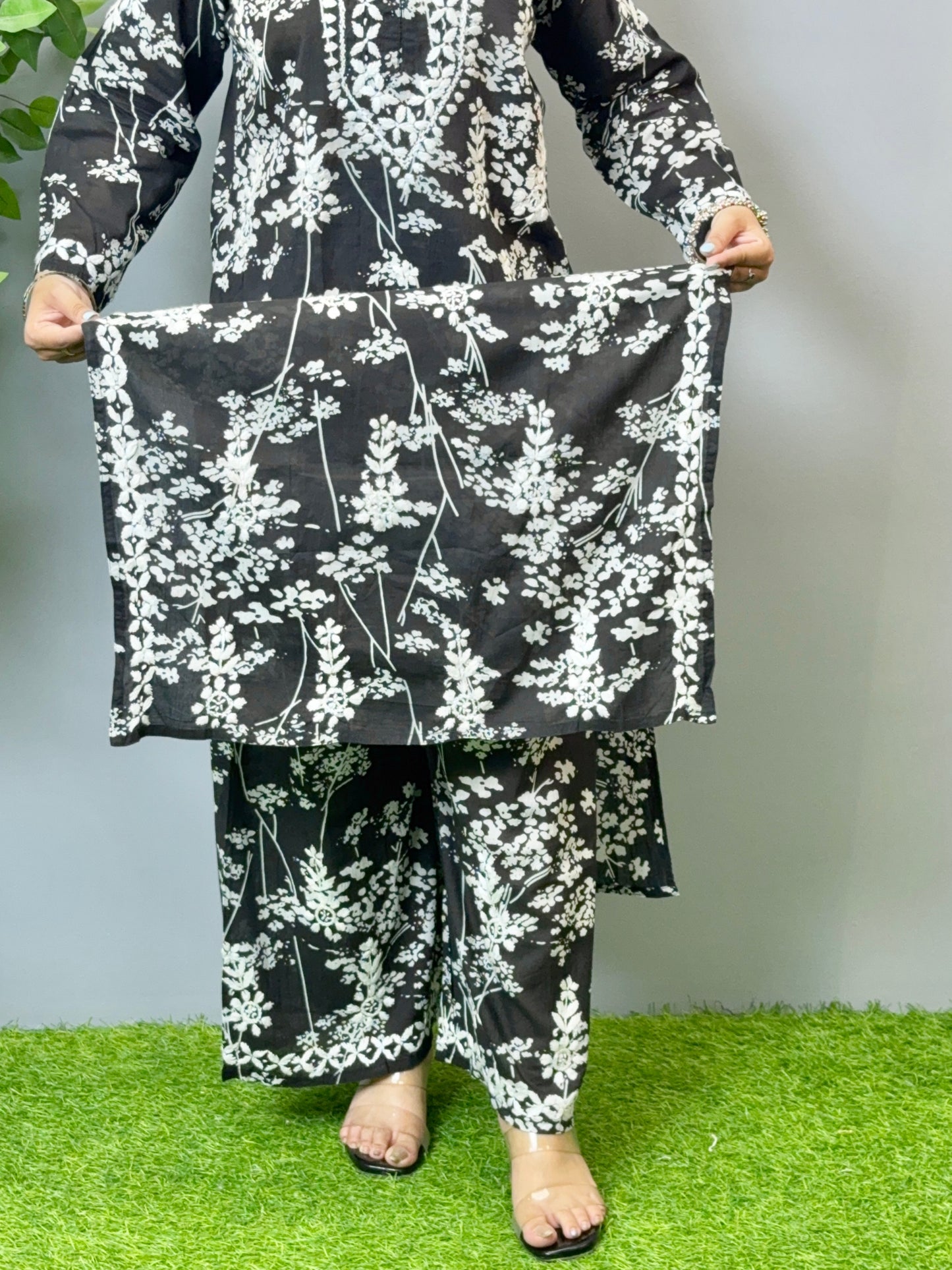 Model wearing a black floral printed Lucknowi chikankari kurta with matching palazzo in mulmul fabric and white embroidery.