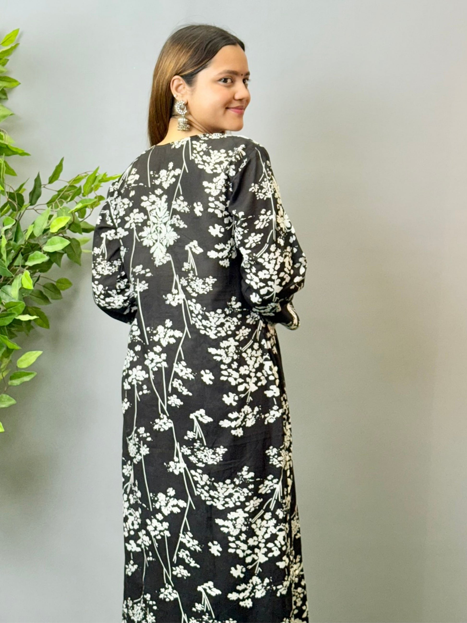 Model wearing a black floral printed Lucknowi chikankari kurta with matching palazzo in mulmul fabric and white embroidery.