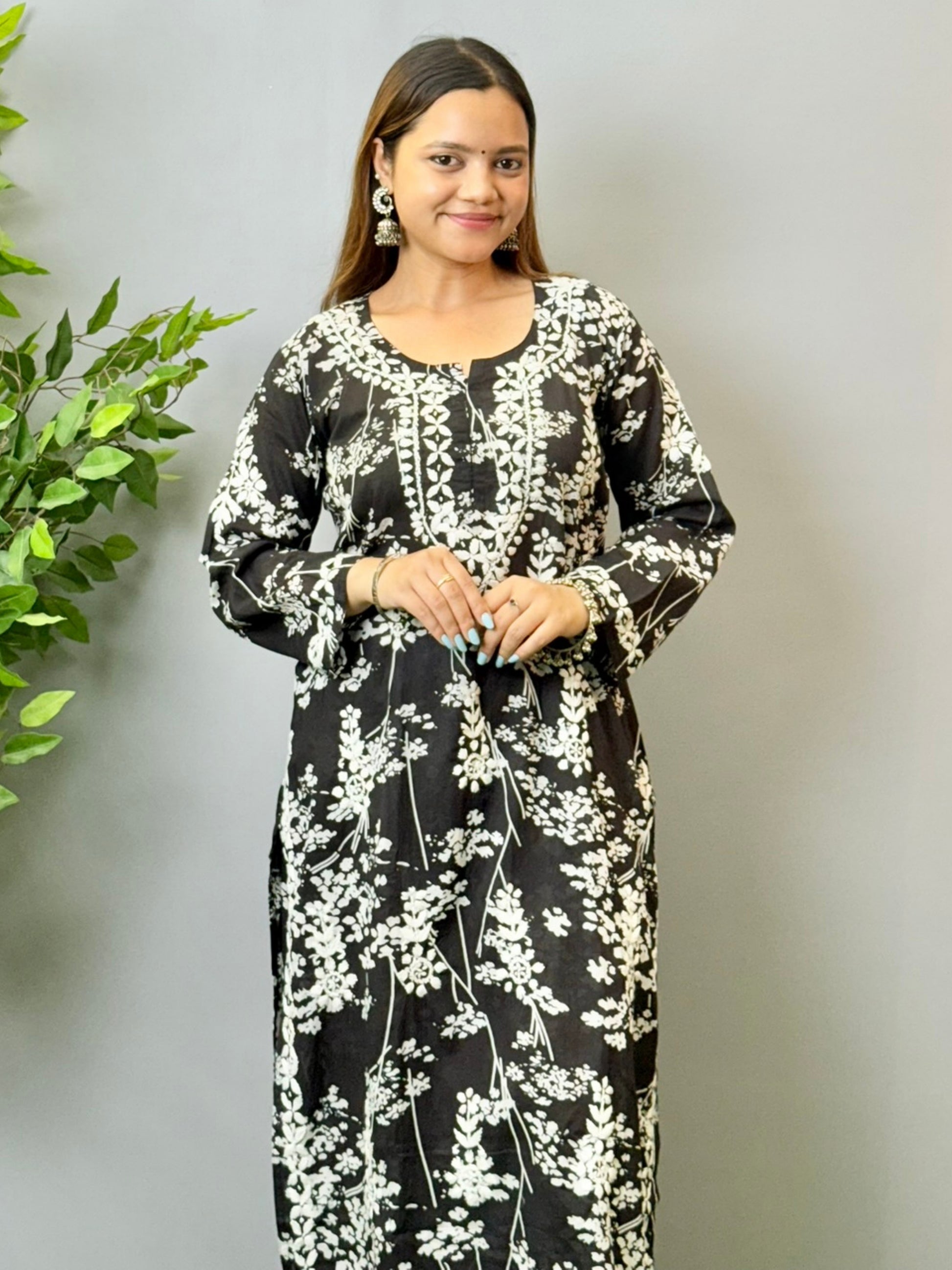 Model wearing a black floral printed Lucknowi chikankari kurta with matching palazzo in mulmul fabric and white embroidery.