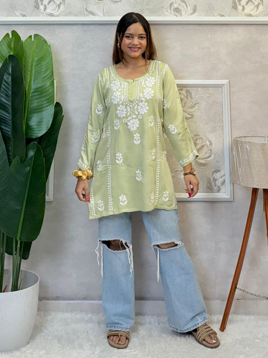 Light green satin short kurta with white Chikankari embroidery, worn with ripped jeans