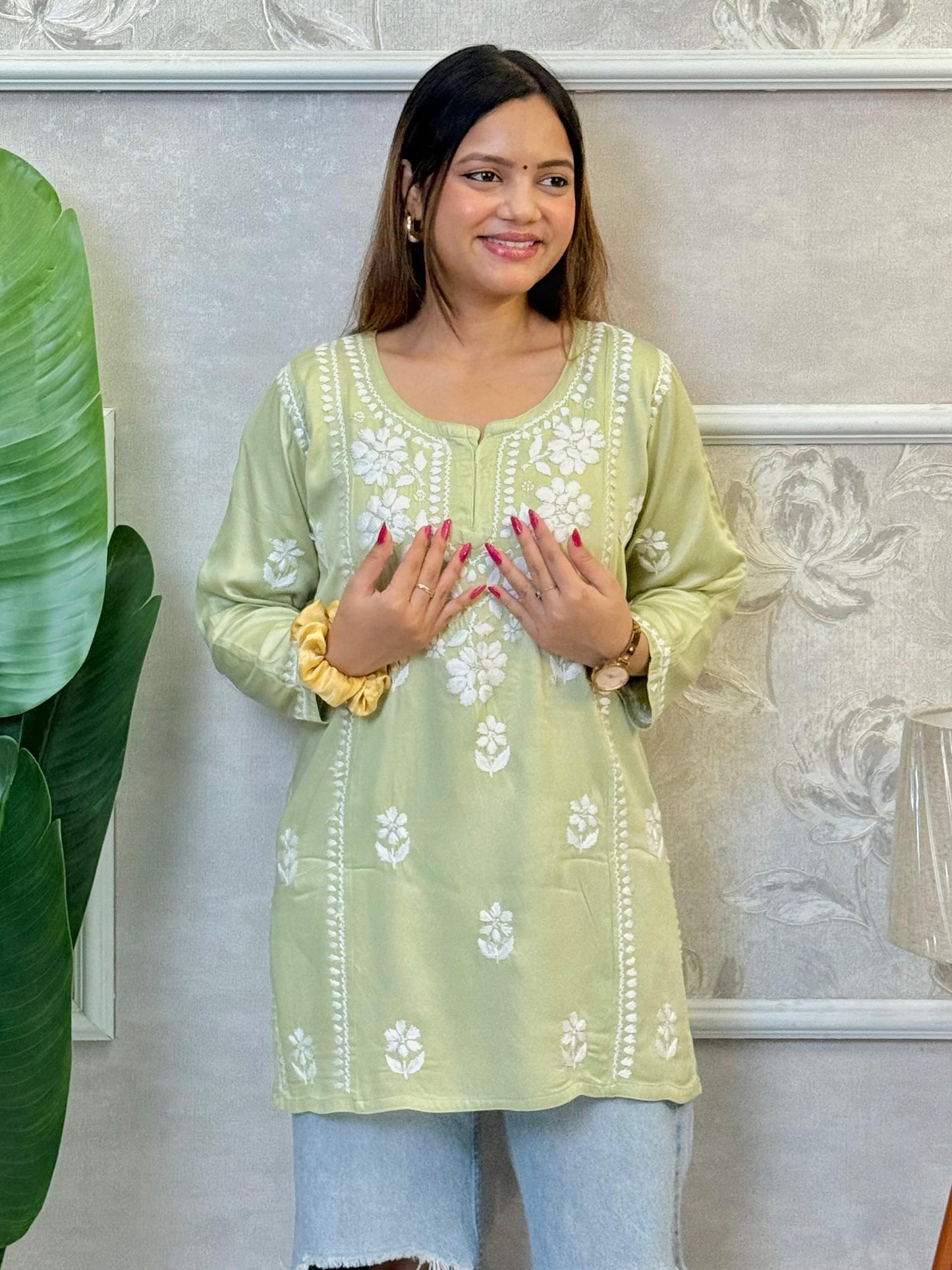 Light green satin short kurta with white Chikankari embroidery, worn with ripped jeans