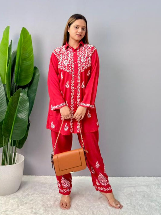 Model wearing a red rayon Lucknowi chikankari co-ord set featuring white hand embroidery on shirt-style kurta and matching pants.