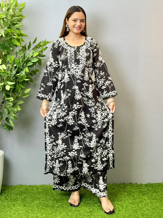 Model wearing a black floral printed Lucknowi chikankari kurta with matching palazzo in mulmul fabric and white embroidery.