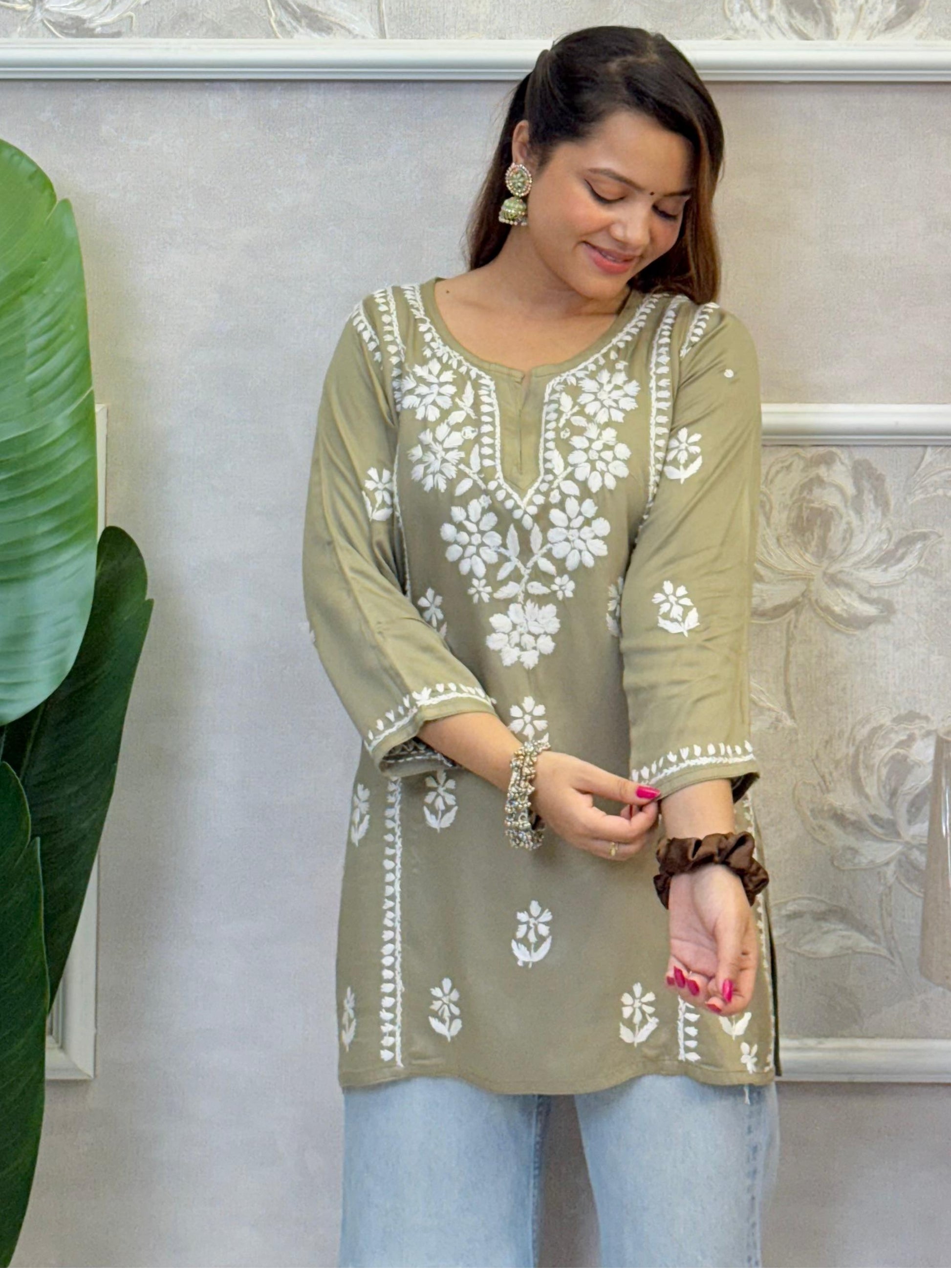 Olive green satin Lucknow Chikankari short kurta with white hand embroidery, full sleeves, and elegant floral patterns.