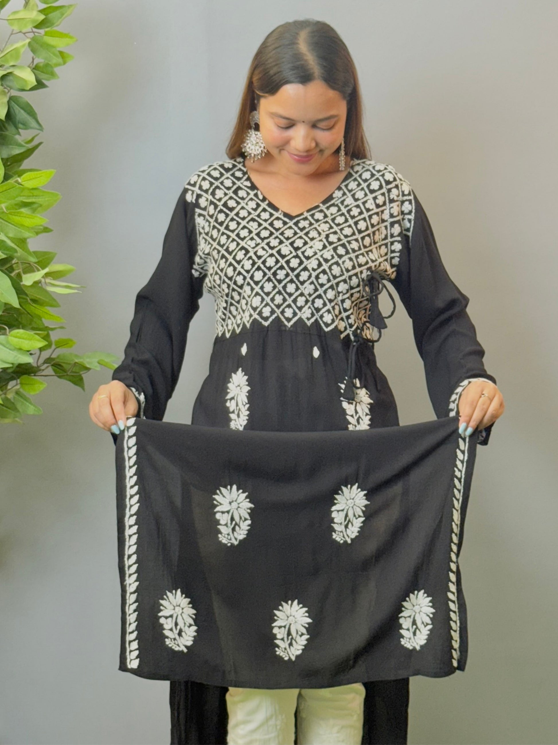 Model wearing a black modal angrakha kurta with elegant white chikankari embroidery and straight silhouette.