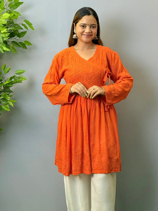 Woman wearing rust orange short chikankari angrakha kurta in viscose fabric
