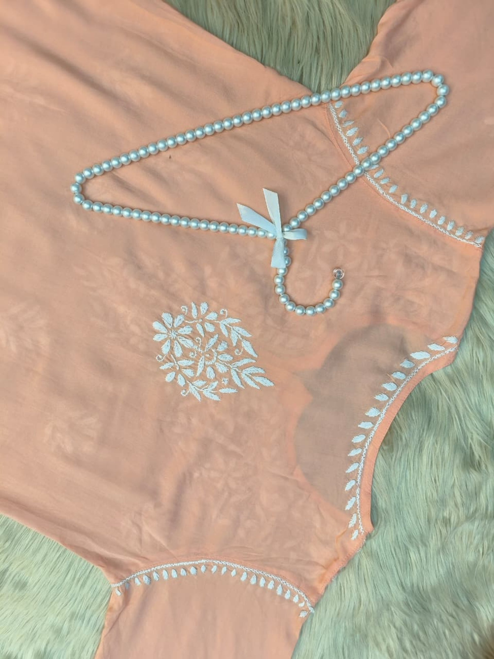 Peach modal short kurta with white hand-embroidered Lucknowi Chikankari design.
