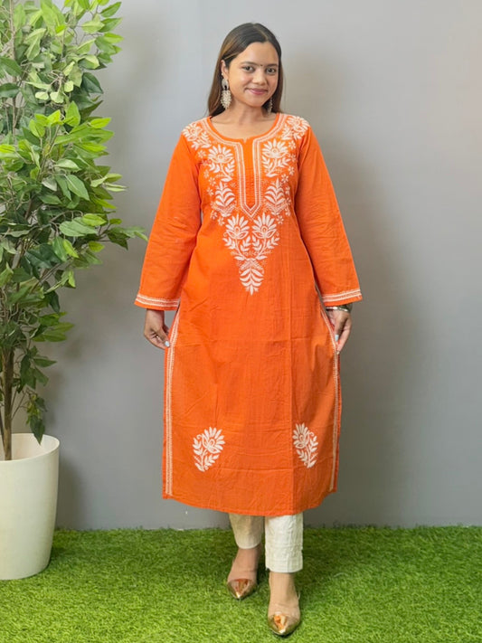 Model wearing a sunset orange cotton kurta with white hand chikankari embroidery.