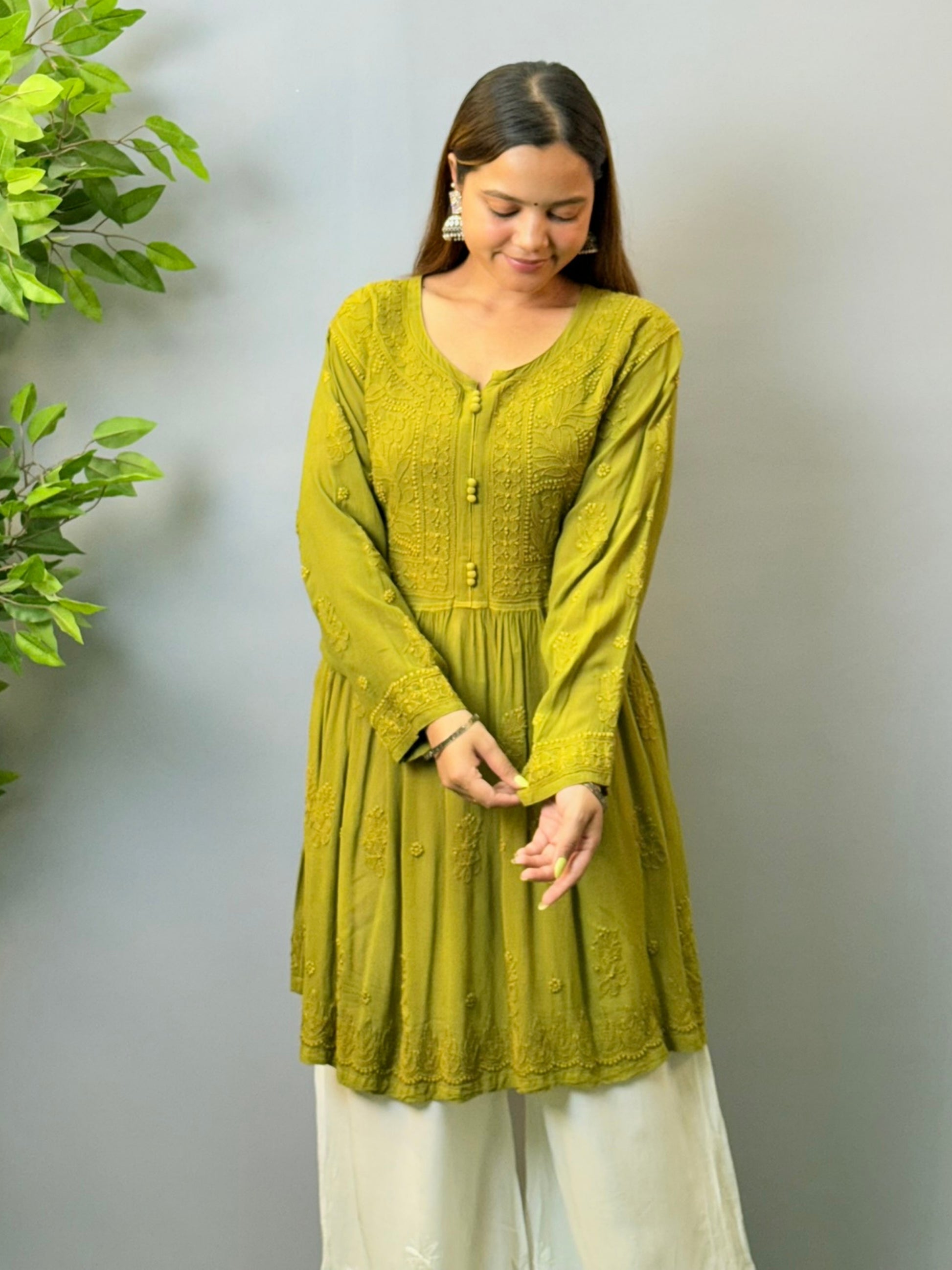 Woman wearing mustard green angrakha-style short chikankari kurta in viscose fabric with flared silhouette