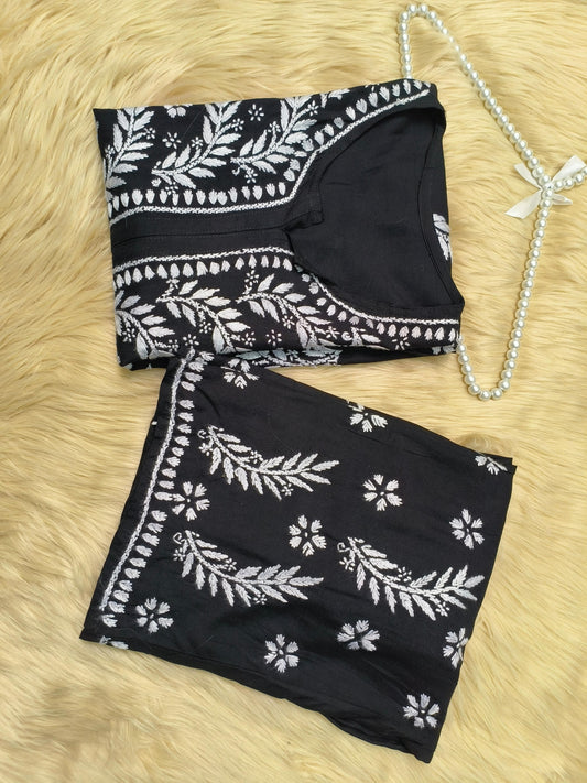 Black rayon chikankari kurta and palazzo set with white hand embroidery displayed on fur background