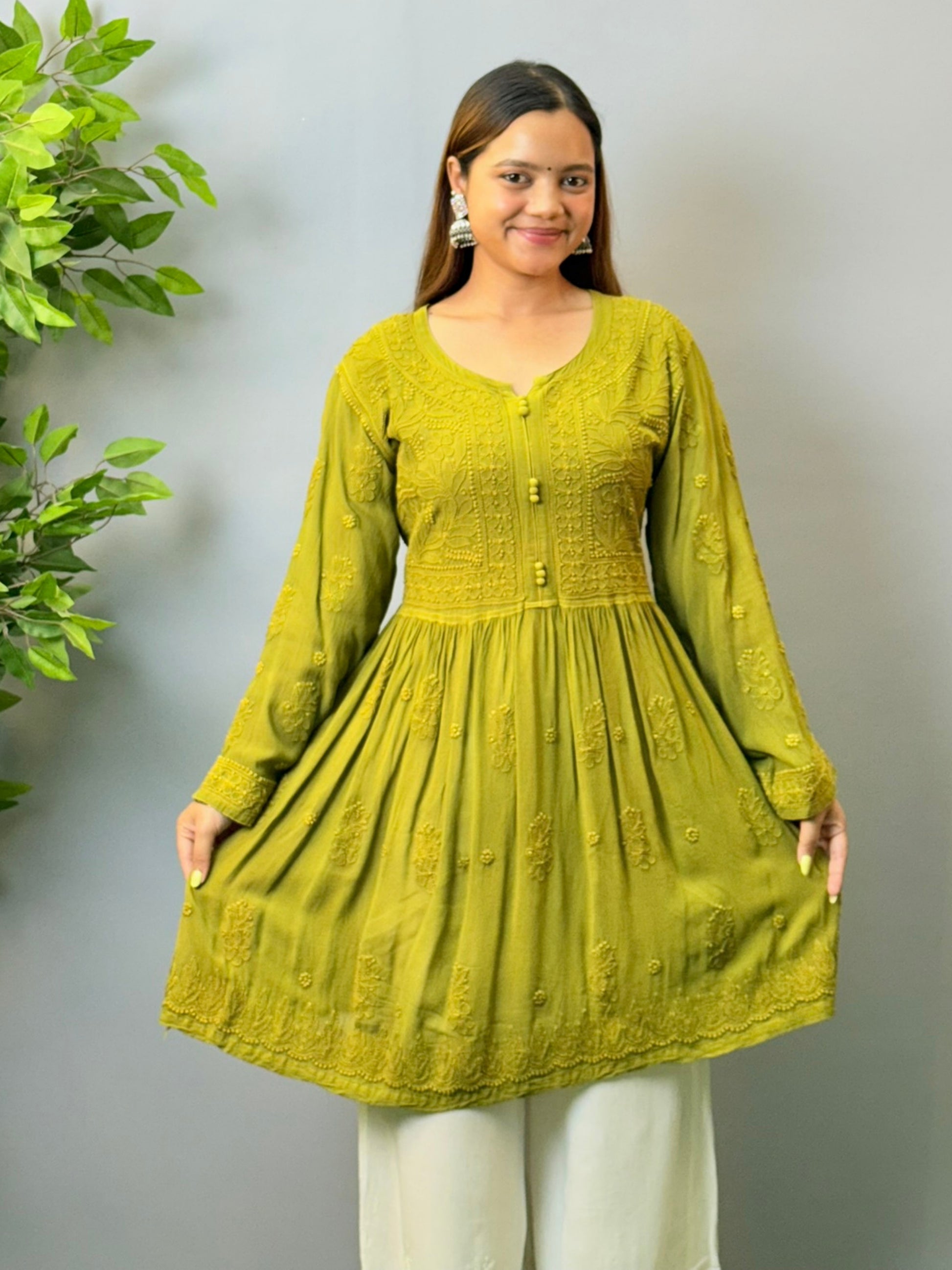 Woman wearing mustard green angrakha-style short chikankari kurta in viscose fabric with flared silhouette