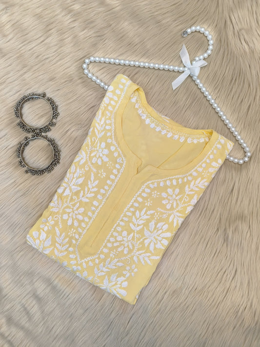 Sunshine yellow modal chikankari kurta with white hand embroidery displayed with pearl hanger and silver bangles