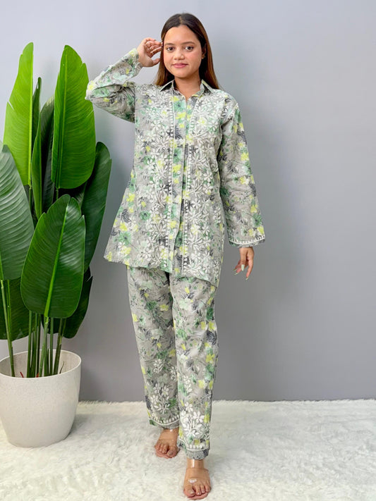 Model wearing a grey printed mulmul chikankari co-ord set with green and yellow floral design, featuring a long shirt-style kurta and matching pants.
