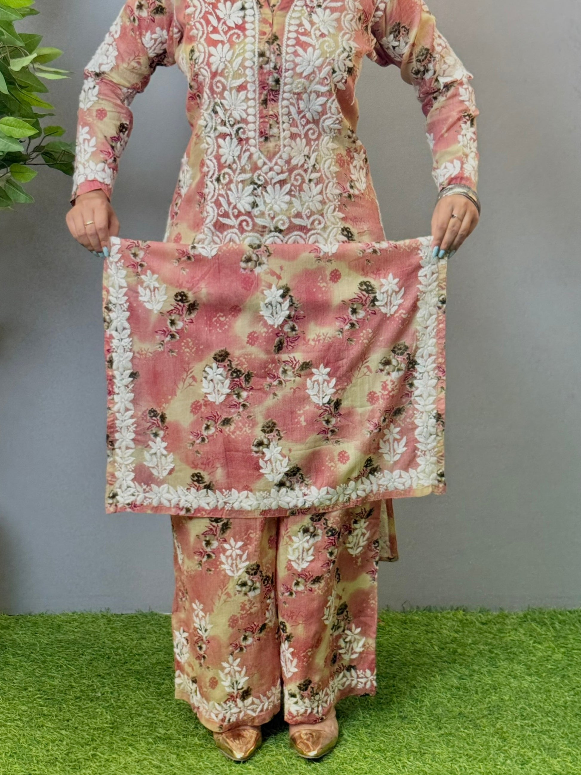 Model wearing a blush peach floral printed chikankari kurta and palazzo set in soft mulmul fabric.