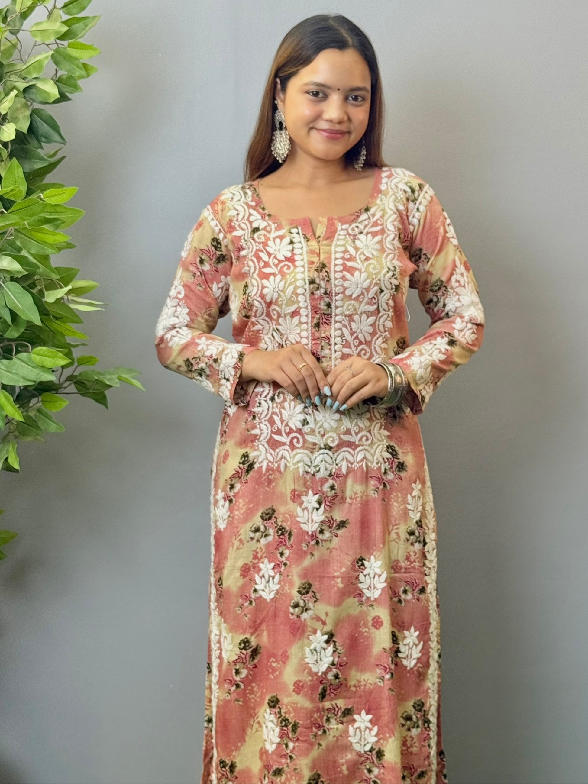 Model wearing a blush peach floral printed chikankari kurta and palazzo set in soft mulmul fabric.