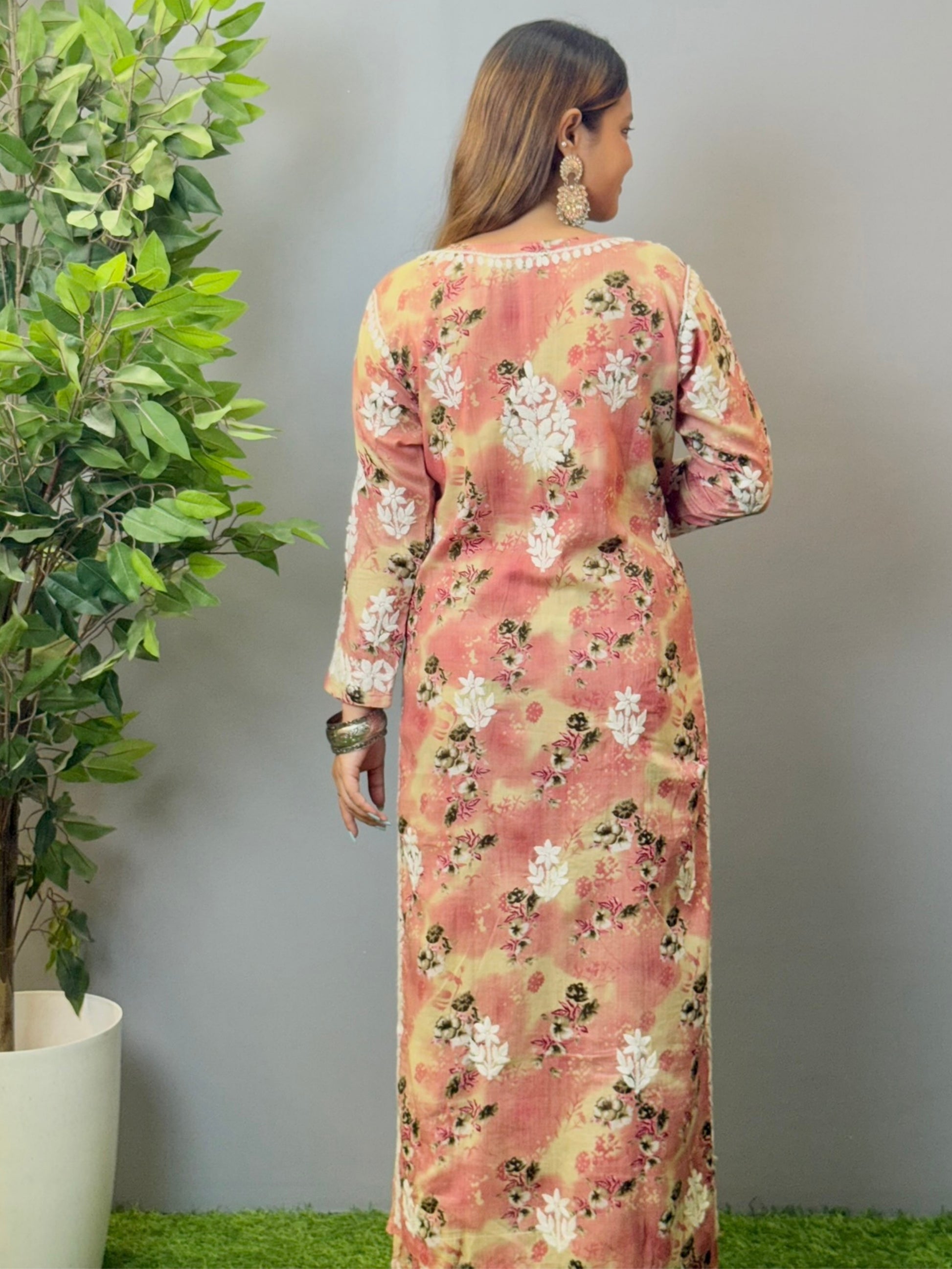 Model wearing a blush peach floral printed chikankari kurta and palazzo set in soft mulmul fabric.