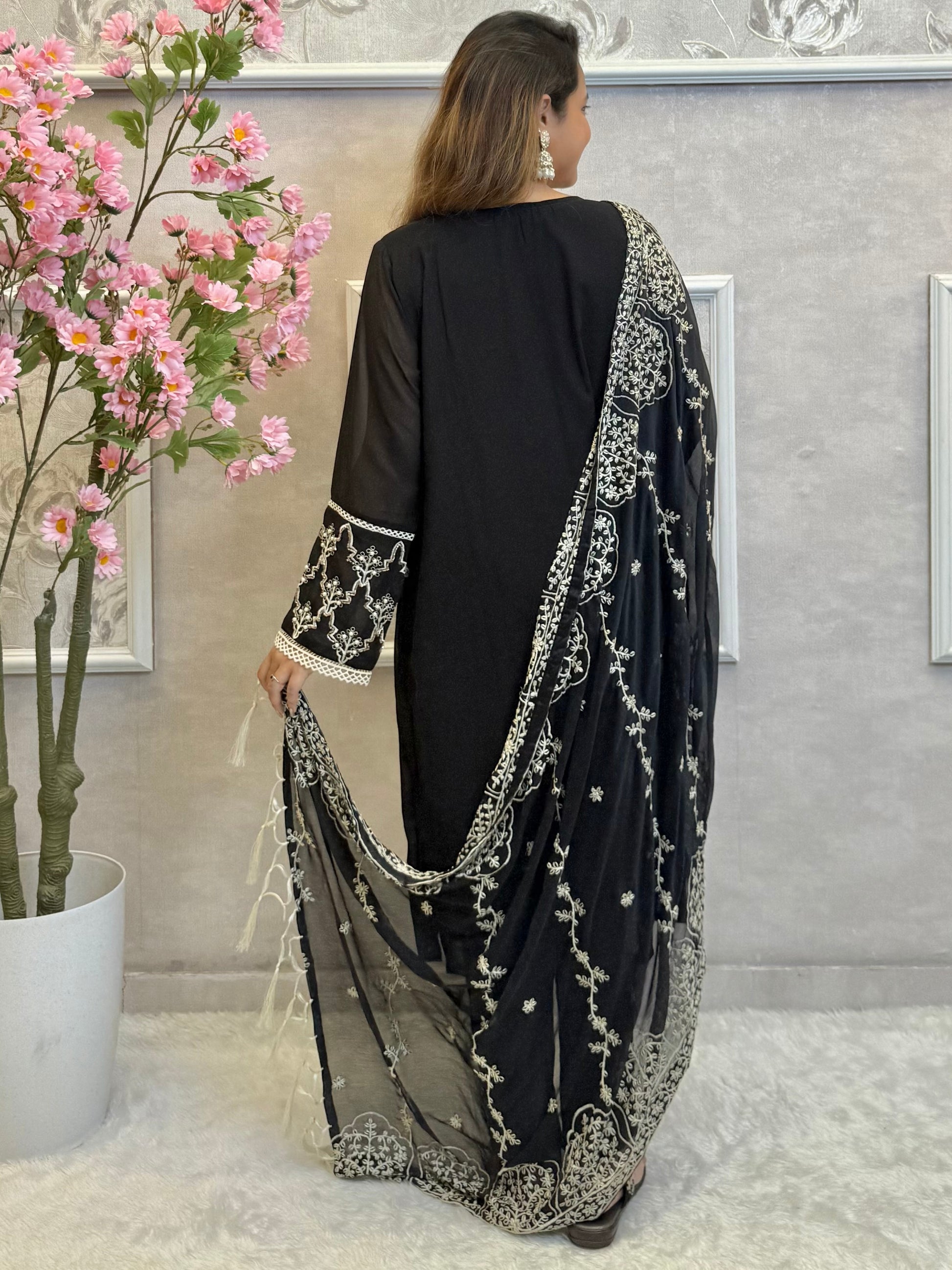Model wearing a black georgette kurta with lycra stretchable pants and embroidered georgette dupatta with tassels – Designer Wear Collection.