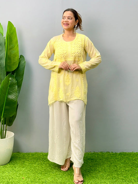 Woman wearing lemon yellow Chikankari short kurta with 3D hand embroidery in viscose fabric and translucent texture