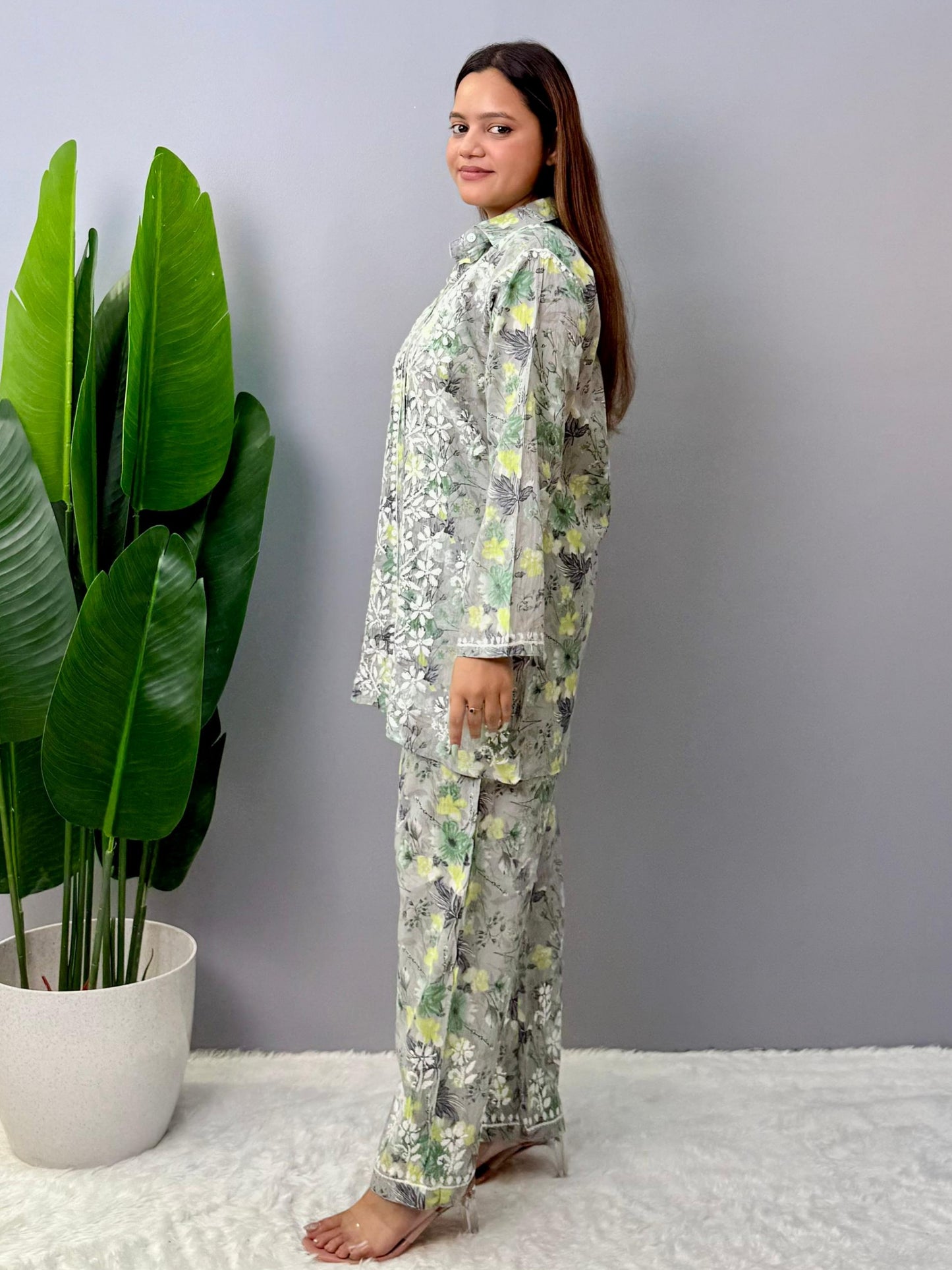 Model wearing a grey printed mulmul chikankari co-ord set with green and yellow floral design, featuring a long shirt-style kurta and matching pants.