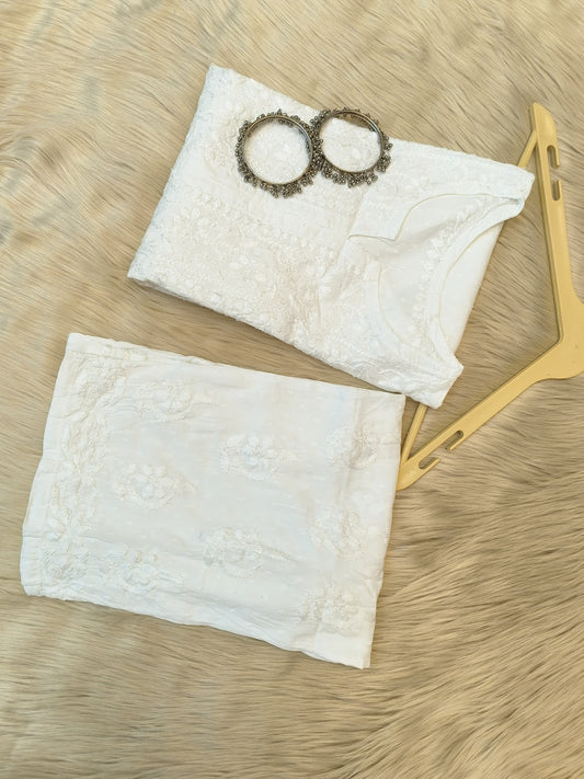 White Chikankari dobby cotton kurta with matching palazzo, bangles and hanger placed on fur background