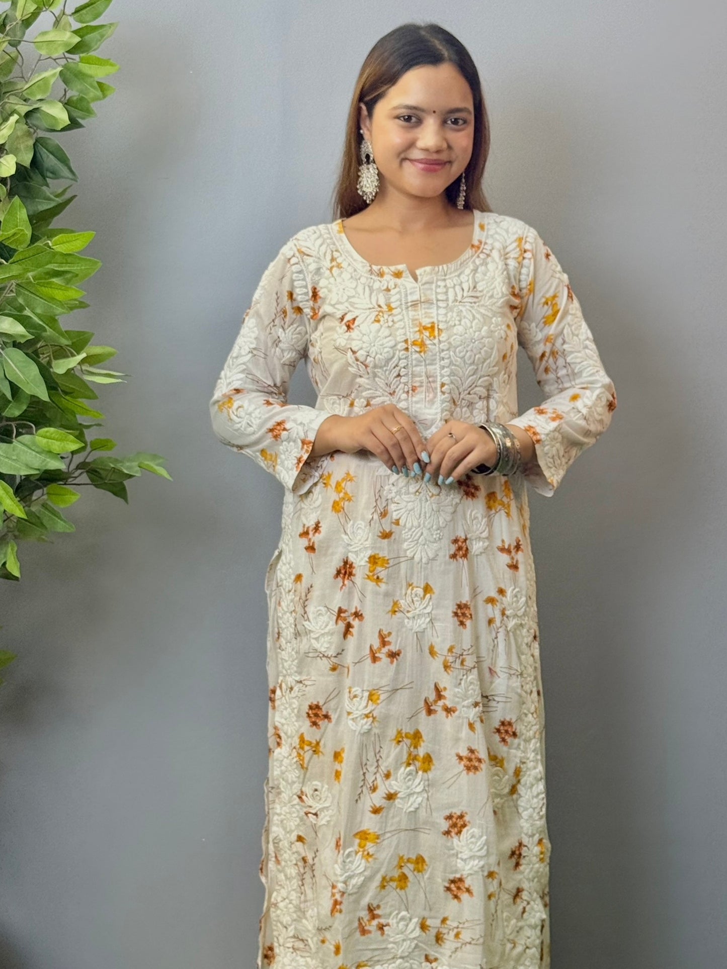 Model wearing ivory mulmul kurta and palazzo set with floral print and 3D hand embroidery.