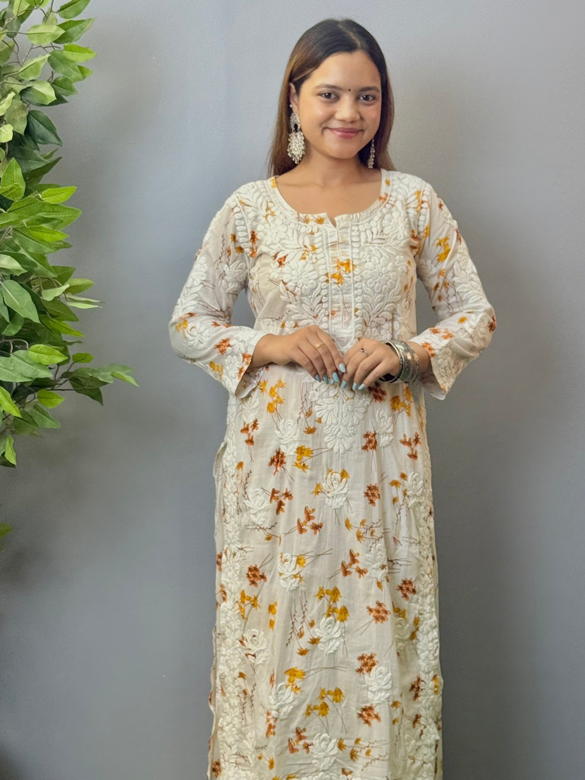 Model wearing ivory mulmul kurta and palazzo set with floral print and 3D hand embroidery.