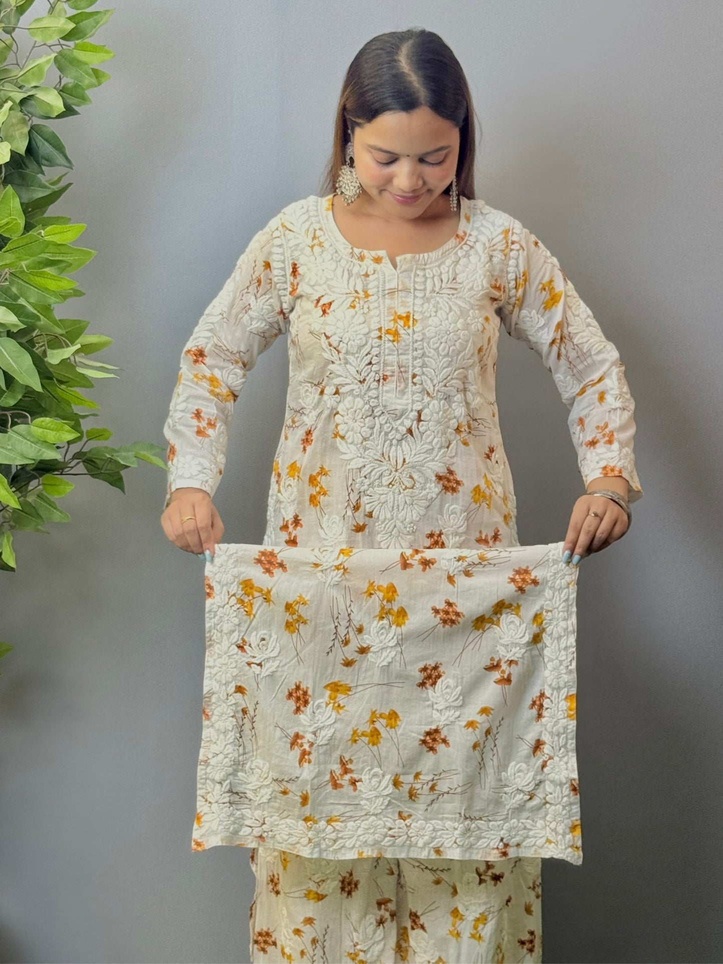 Model wearing ivory mulmul kurta and palazzo set with floral print and 3D hand embroidery.