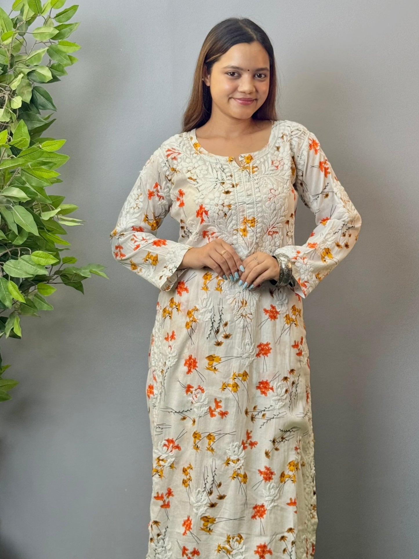 Model wearing ivory floral printed mulmul chikankari kurta and palazzo set with detailed 3D embroidery.