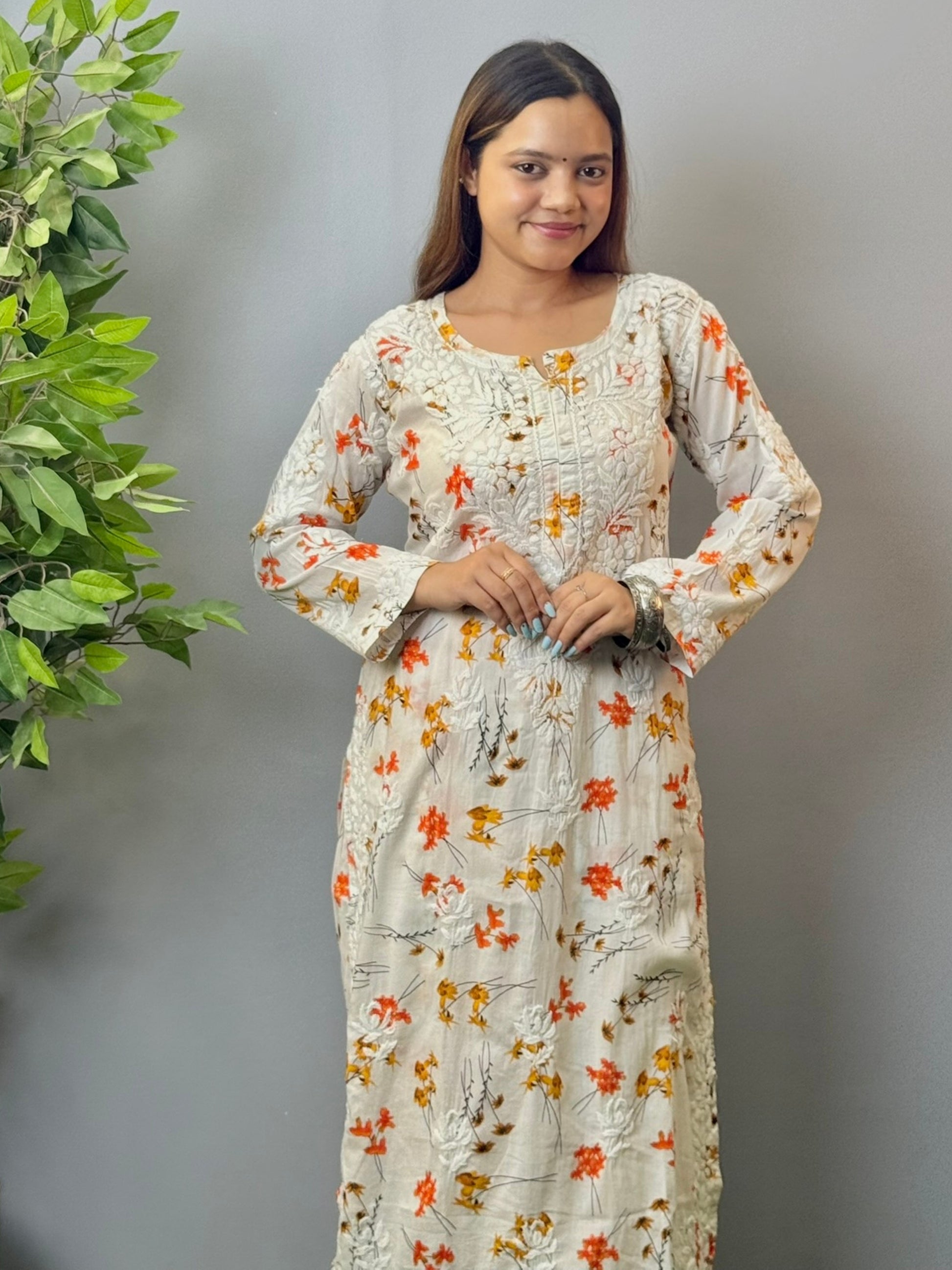 Model wearing ivory floral printed mulmul chikankari kurta and palazzo set with detailed 3D embroidery.