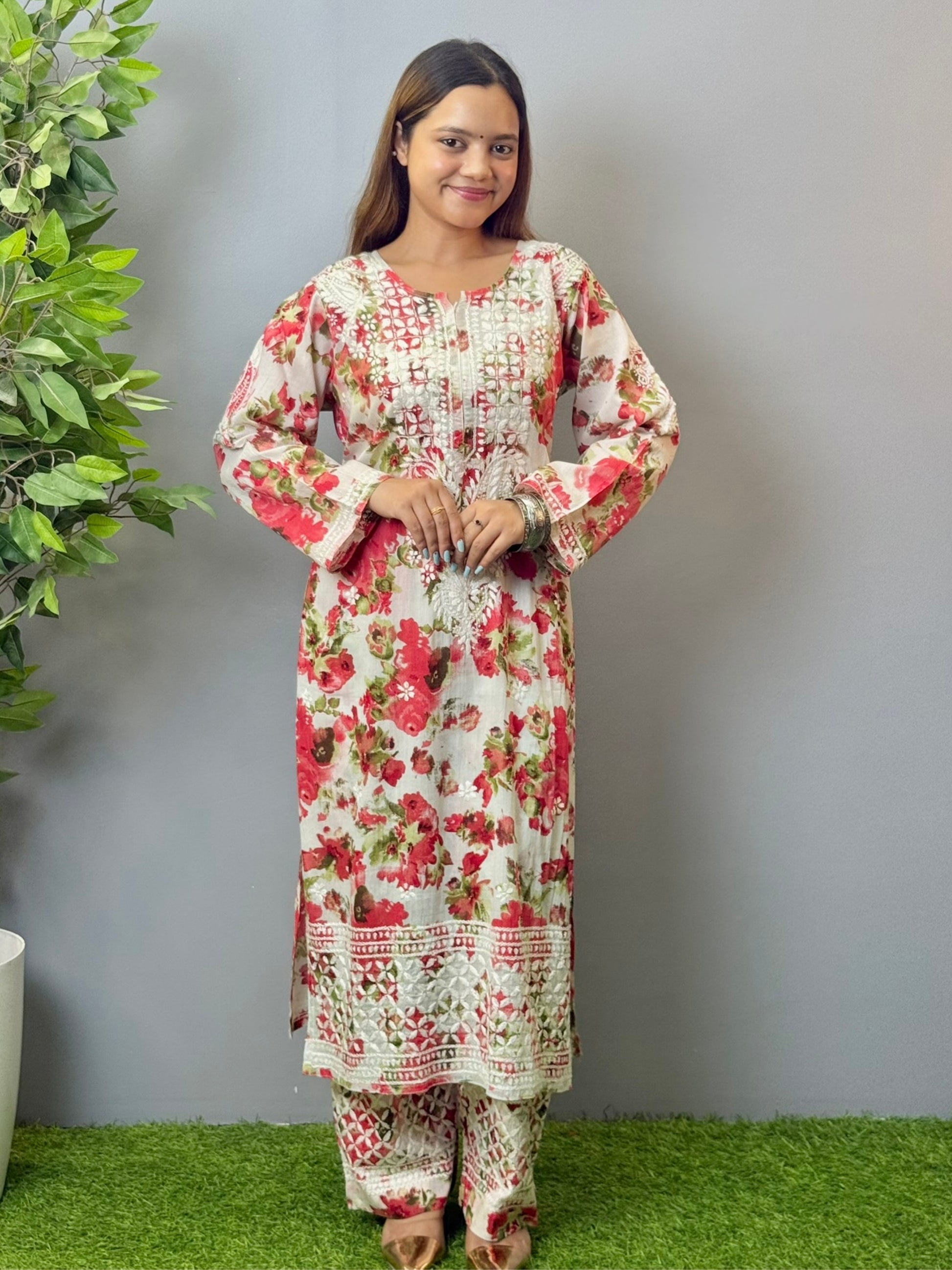 Model wearing floral white mulmul Lucknow chikankari kurta and pant set with pink rose print and white embroidery.