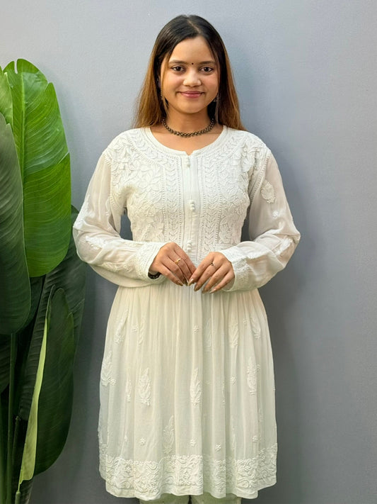 Model wearing a white flared chikankari short kurta with all-over hand embroidery in viscose fabric