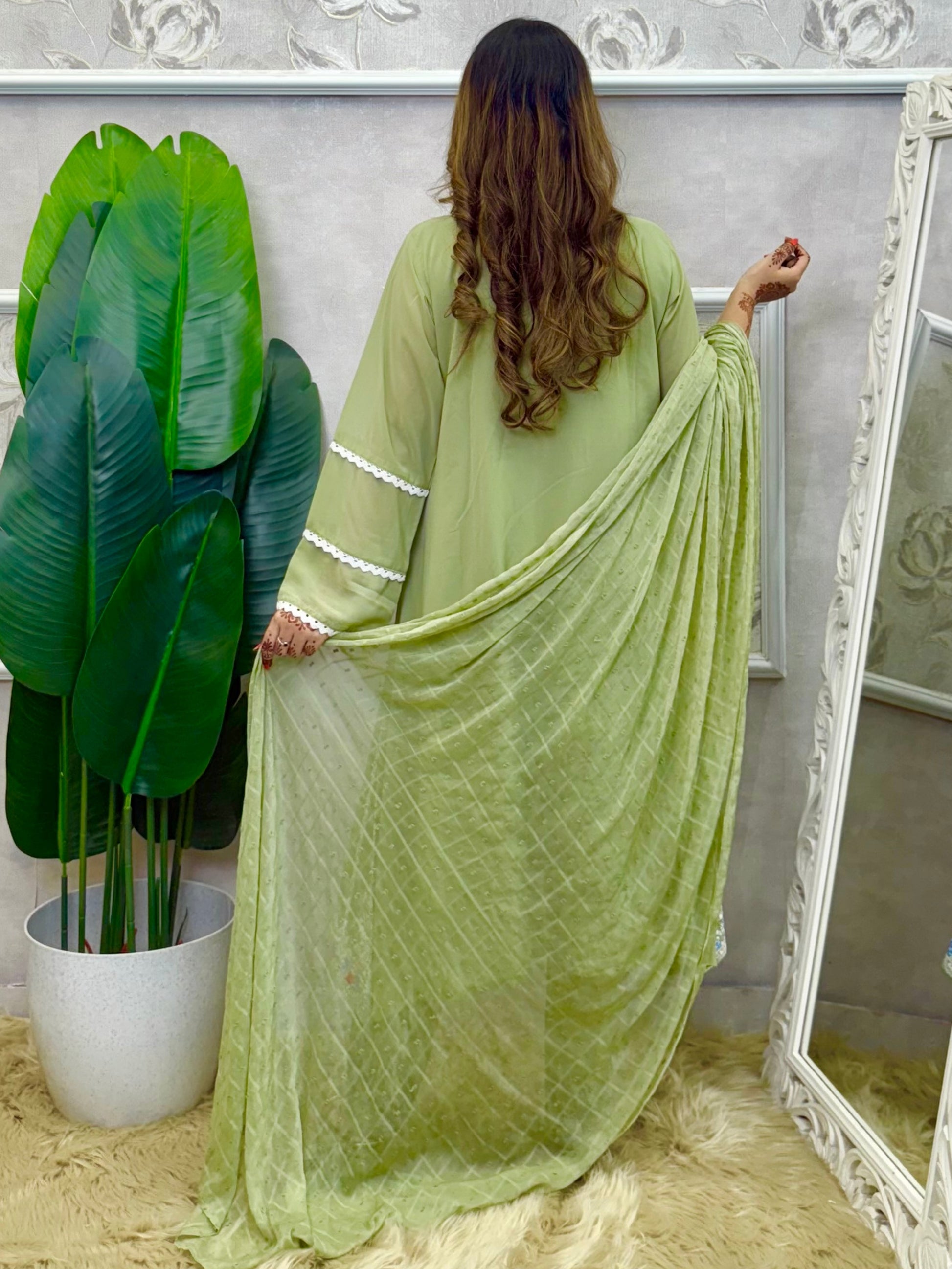 Model wearing a sage green embroidered georgette kurta with lycra stretchable pants and a chiffon dupatta – Designer Wear Collection.