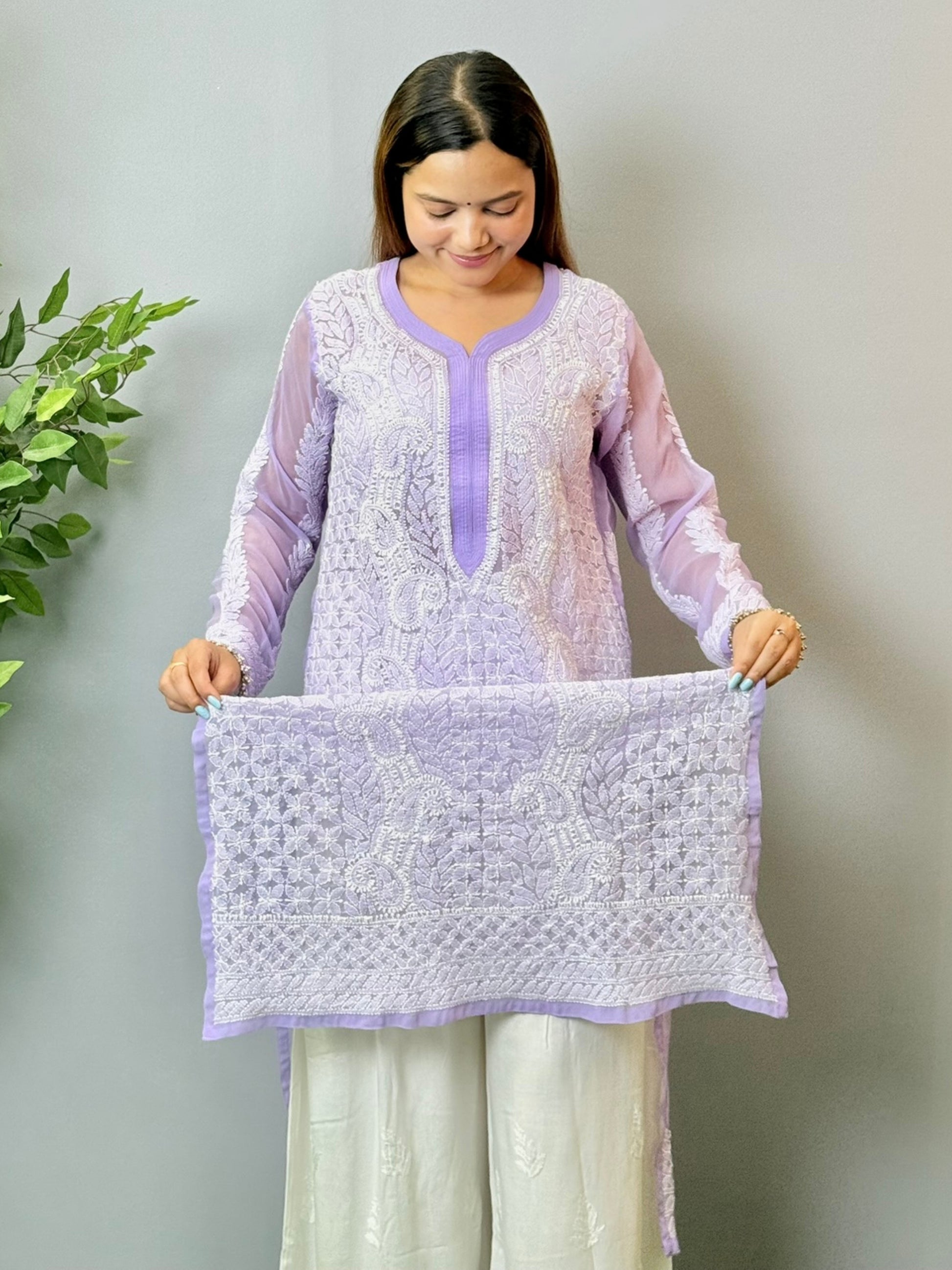 Model wearing a lavender translucent georgette Lucknowi chikankari kurta with heavy hand embroidery, styled with white palazzos for a festive look.