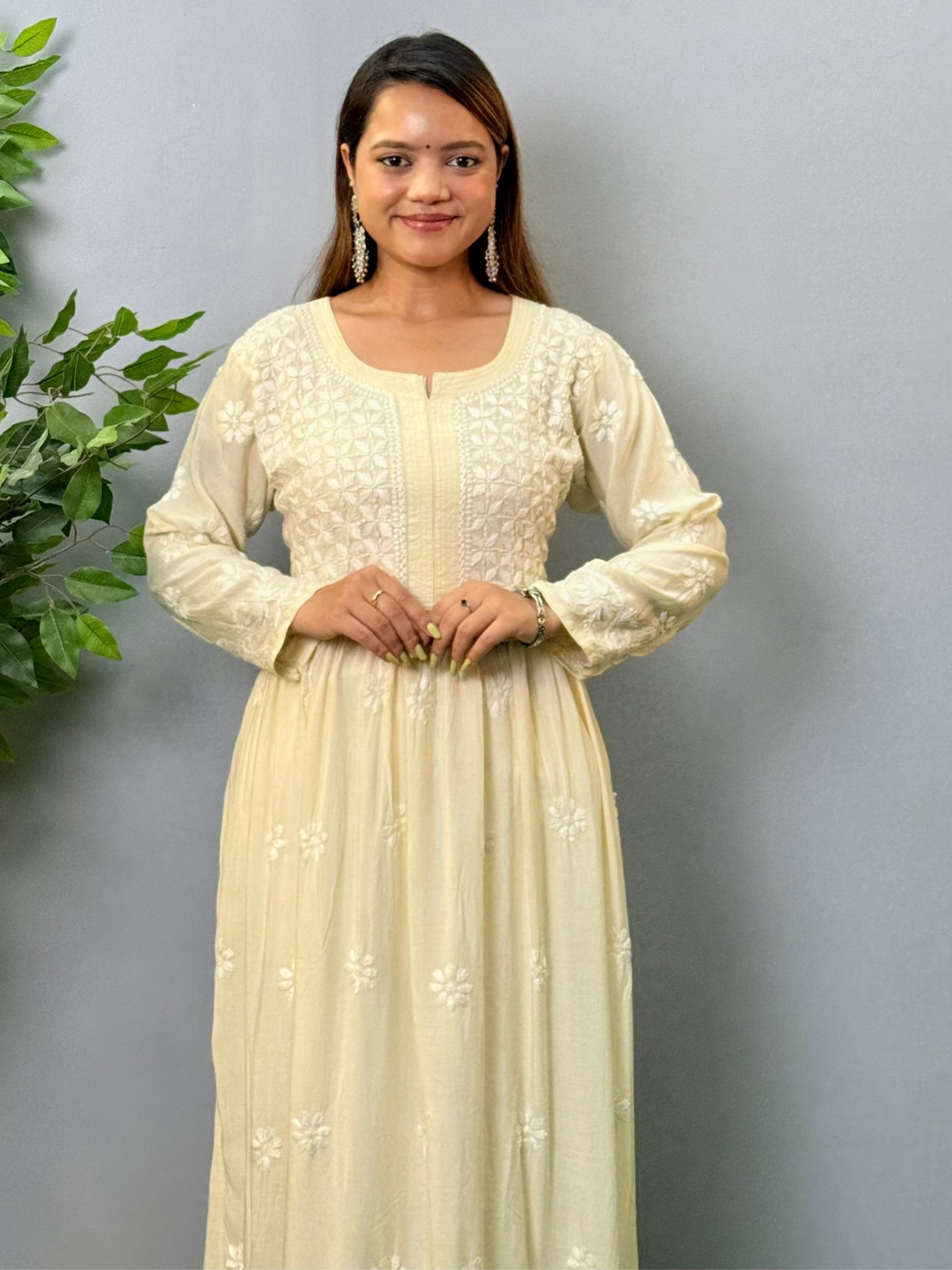 Model wearing an ivory long frock-style modal chikankari kurta with detailed embroidery