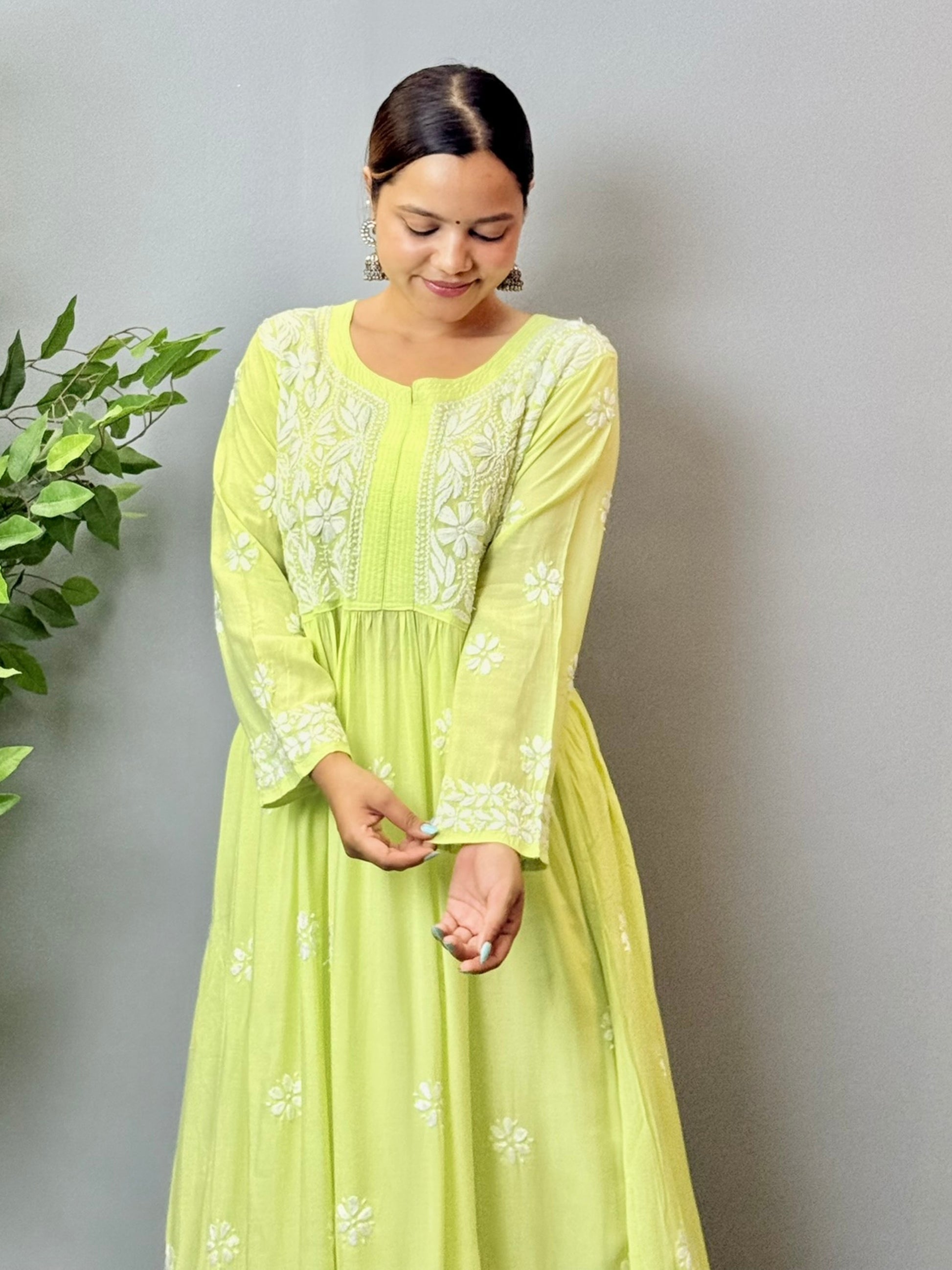 Model wearing a lime green Lucknowi chikankari long frock in modal fabric with delicate white hand embroidery and flared silhouette.