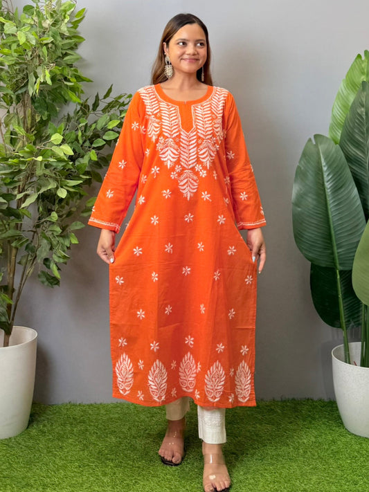 Model wearing a bright orange cotton chikankari kurta with white hand embroidery