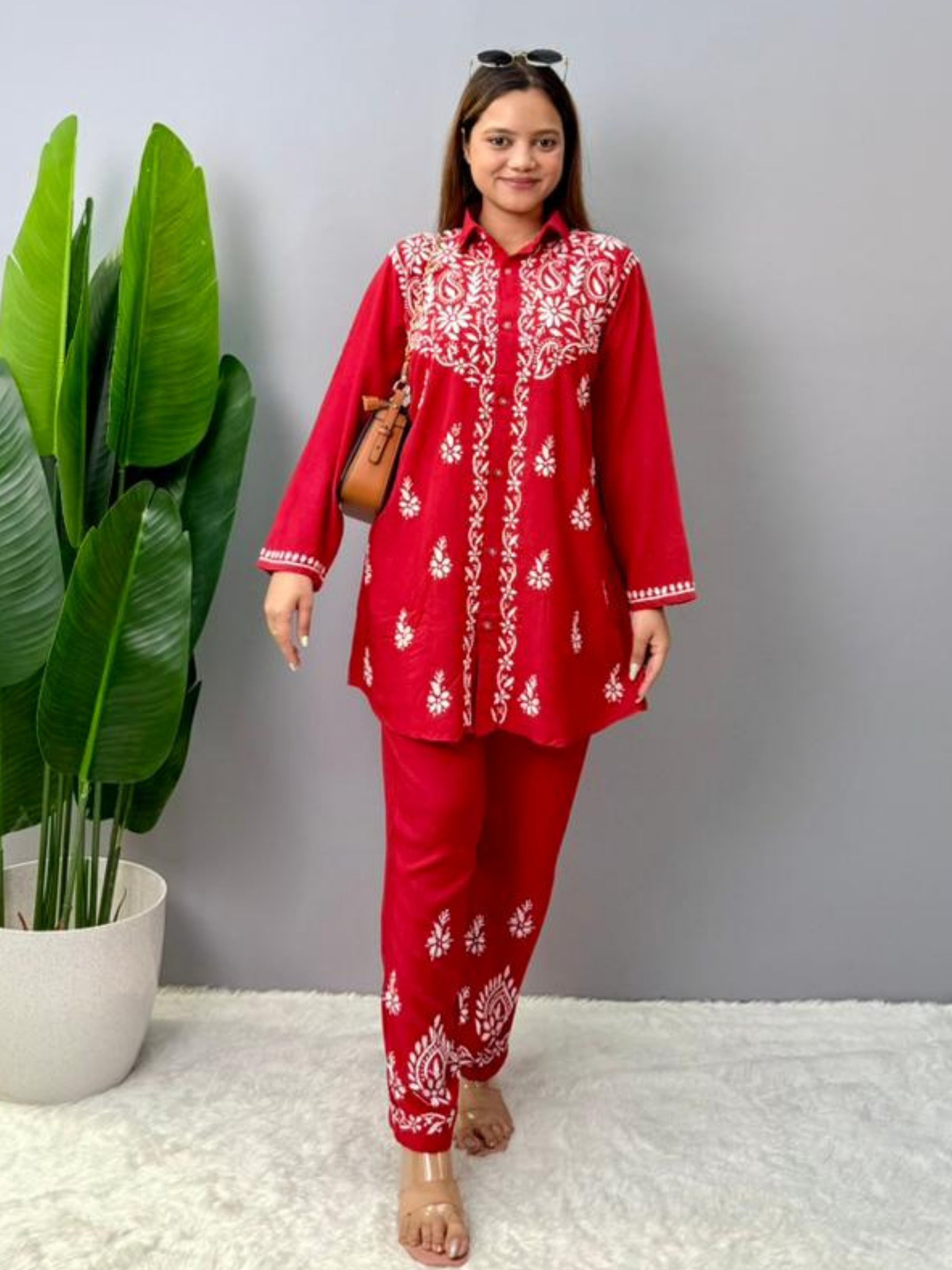 Model wearing a red rayon Lucknowi chikankari co-ord set featuring white hand embroidery on shirt-style kurta and matching pants.